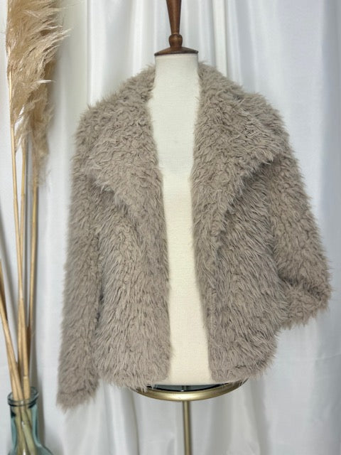 neutral colored bohemian shag jacket with pockets on display with a pampas