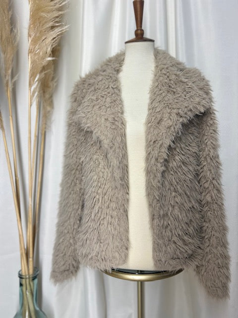 neutral colored bohemian shag jacket on display with a pampas