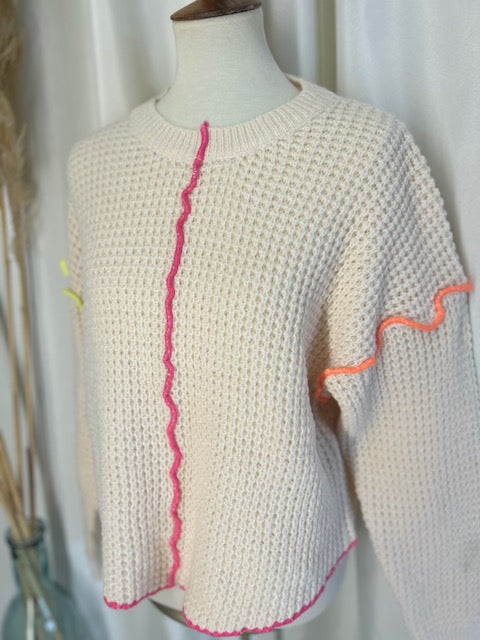 cream color waffle knit sweater with neon stitching displayed on a mannequin