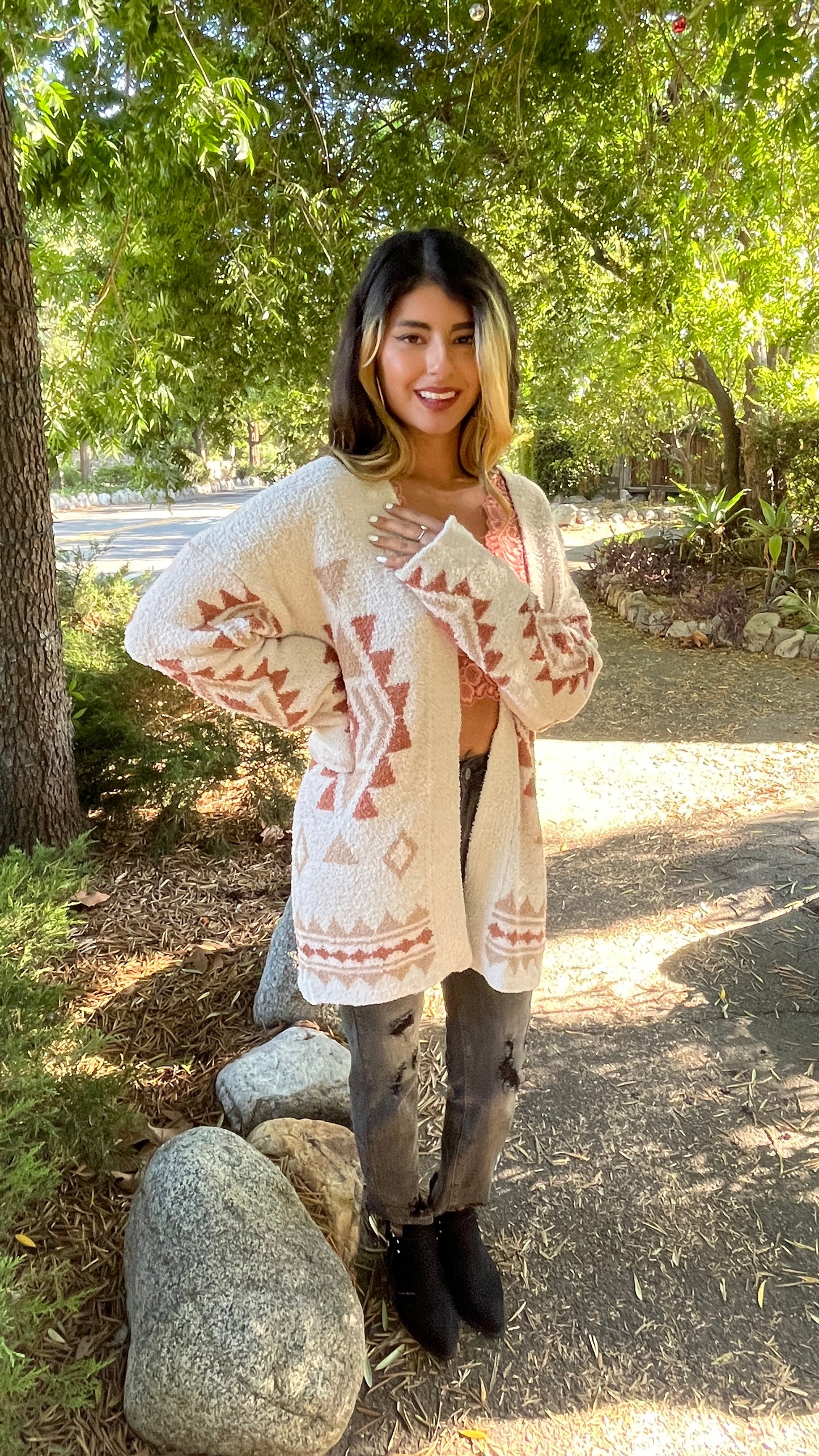 model wearing size small in a boho print cardigan sweater on a sunny day