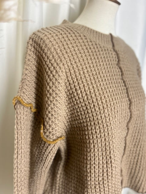sideview of mocha waffle knit sweater to show off the contrast light brown stitching detail